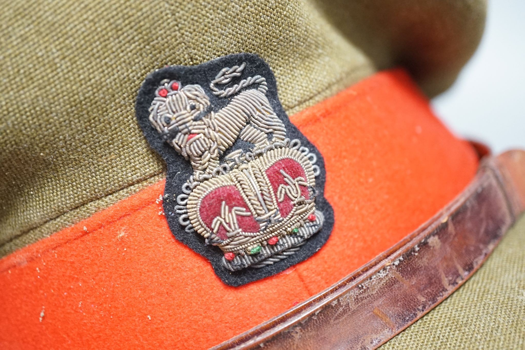 Two army officers' caps in brown leather hat box.